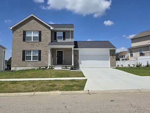a brick house with a white garage door and a sidewalk in front